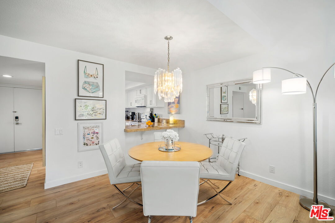 60 La Ronda Drive Rancho Mirage, CA 92270 - Photo 16 of 57 a dining room with wooden floor a chandelier a wooden table and chairs