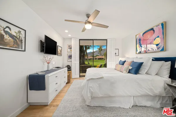 a bedroom with a large bed and a flat screen tv