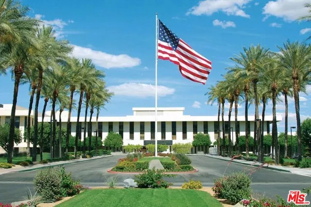 a view of a balcony with chairs potted plants