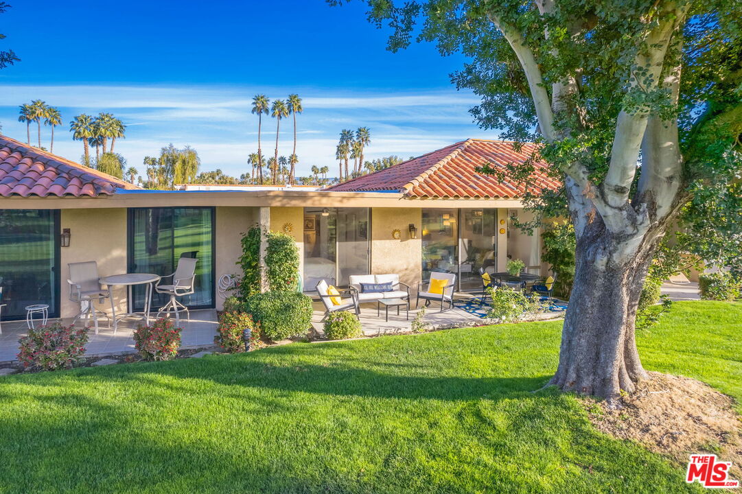 60 La Ronda Drive Rancho Mirage, CA 92270 - Photo 55 of 57 a front view of a house with a yard table and chairs