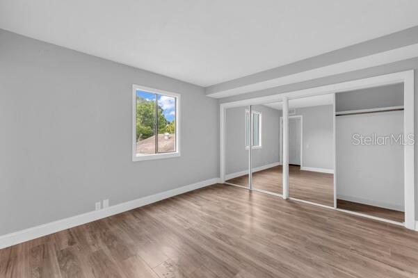 1502 Lake Buckeye Road, Unit 2 Winter Haven, FL 33881 - Photo 32 of 47 an empty room with wooden floor closet and windows