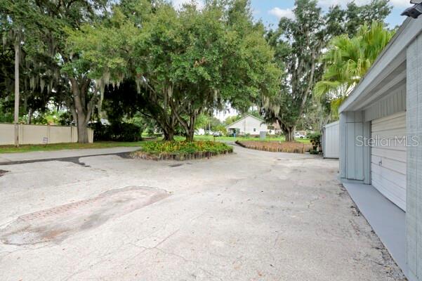 1502 Lake Buckeye Road, Unit 2 Winter Haven, FL 33881 - Photo 35 of 47 a view of a backyard with plants and large trees