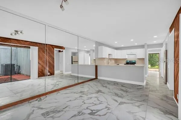 a view of a hallway with wooden floors and kitchen view
