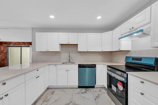 1502 Lake Buckeye Road, Unit 2 Winter Haven, FL 33881 - Photo 9 of 47 a kitchen with white cabinets sink and white appliances