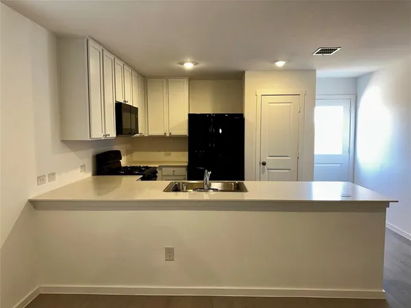 a kitchen with stainless steel appliances granite countertop a sink a refrigerator and a granite counter tops