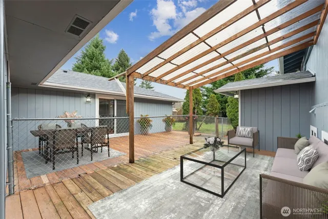 a view of a patio with table and chairs with wooden floor and fence