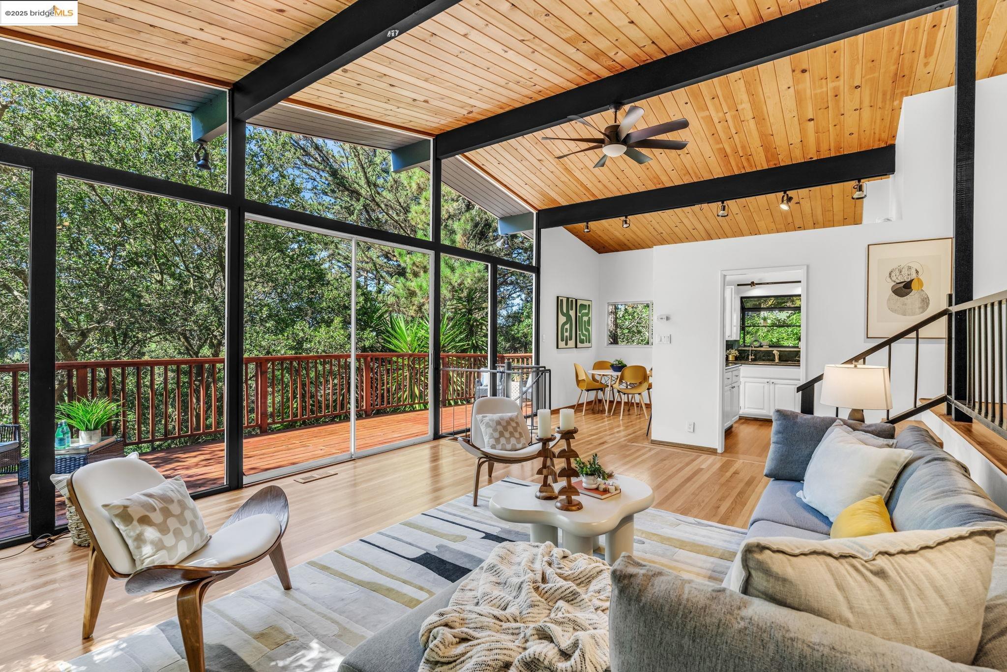 2211 Arrowhead Drive Oakland, CA 94611 - Photo 15 of 52 Living room featuring a wood ceiling with exposed beams, light wood finished floors, high vaulted ceiling, a wall of windows, and stairway