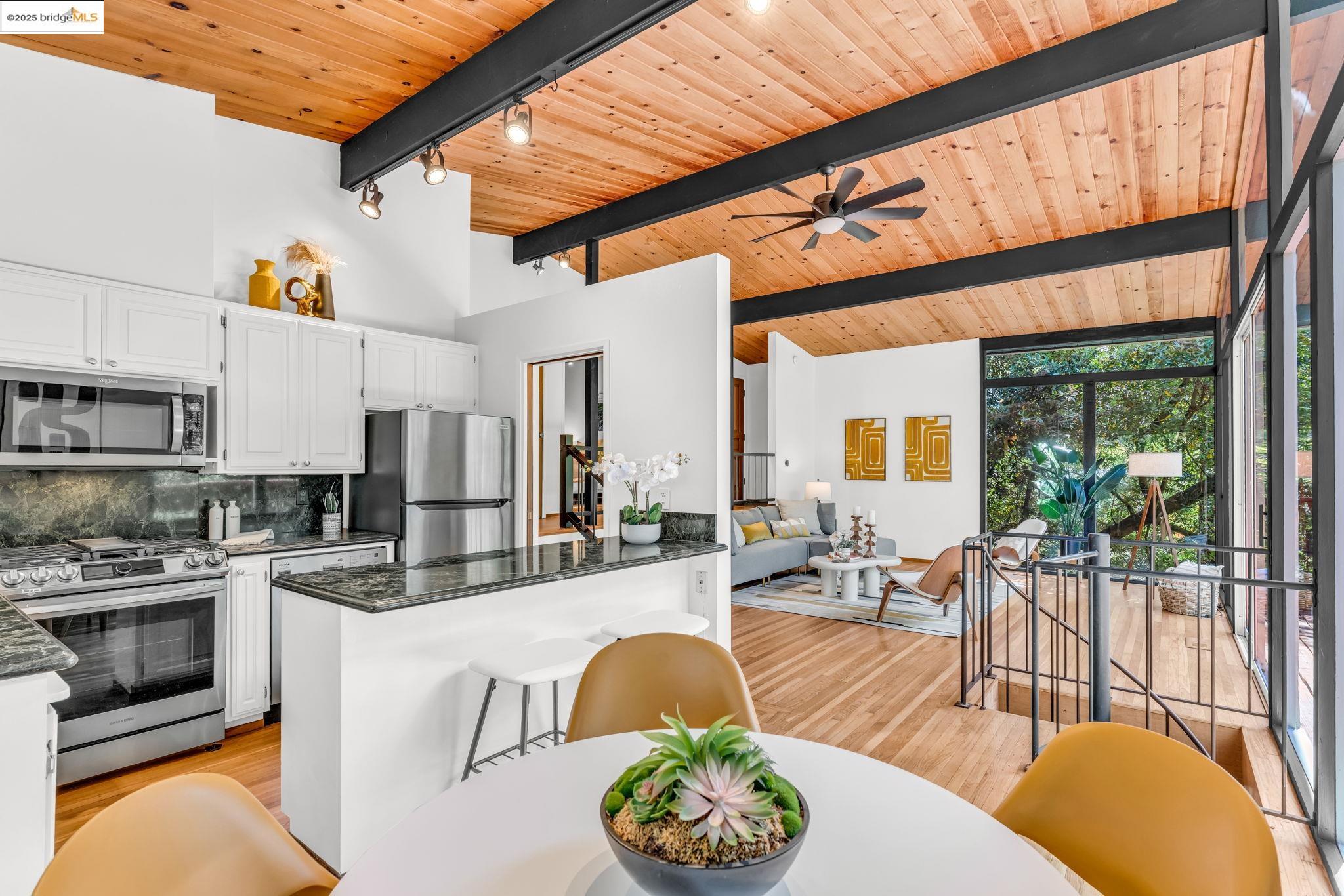 2211 Arrowhead Drive Oakland, CA 94611 - Photo 25 of 52 Kitchen with white cabinetry, a wooden ceiling with exposed beams, stainless steel appliances, tasteful backsplash, and dark stone countertops