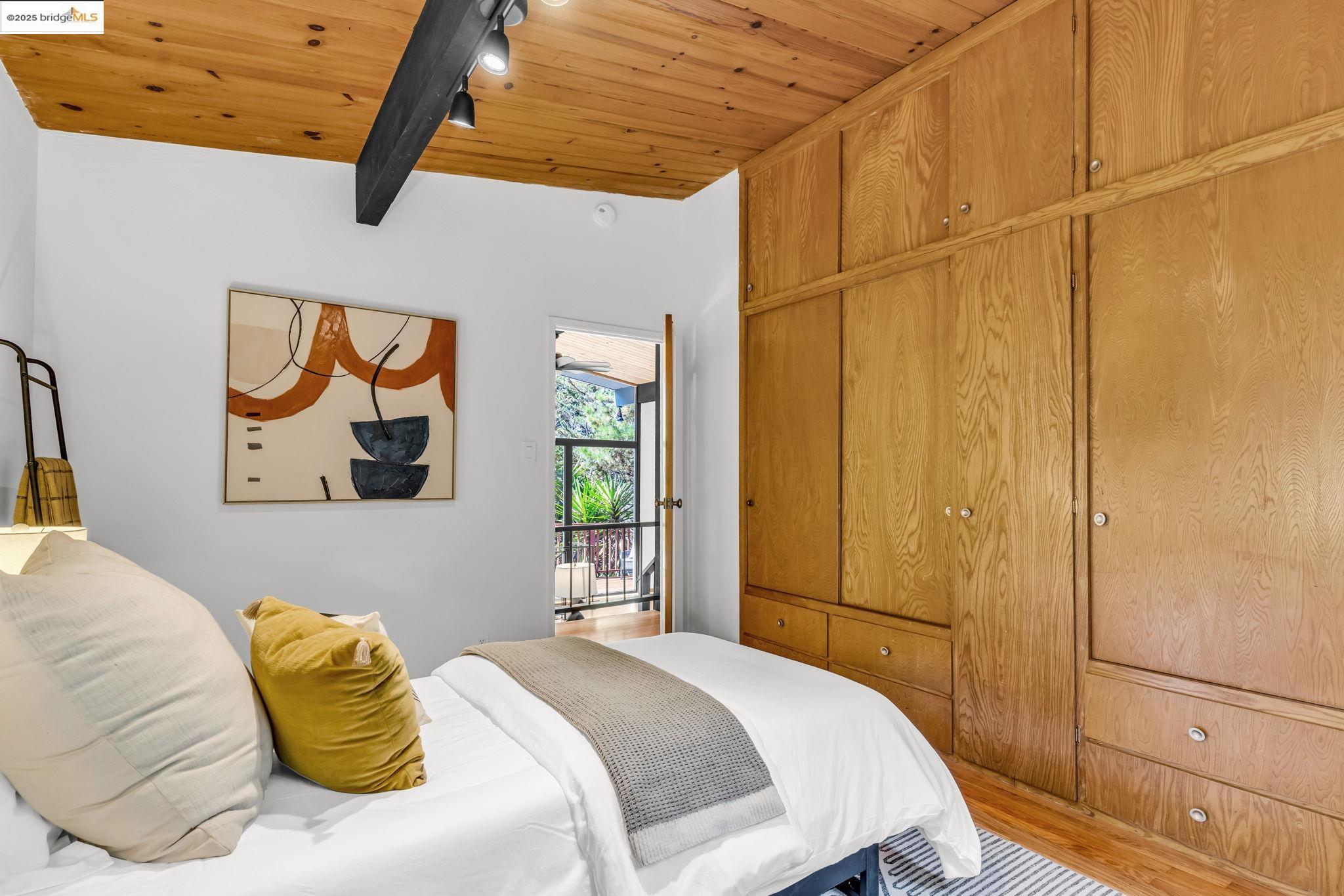 2211 Arrowhead Drive Oakland, CA 94611 - Photo 34 of 52 Bedroom featuring a wooden ceiling with exposed beams, wood finished floors, and rail lighting