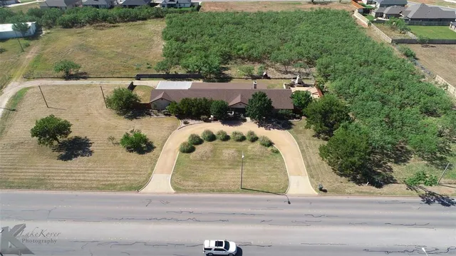 an aerial view of a house with a yard and lake view