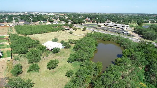 an aerial view of residential houses with outdoor space and trees