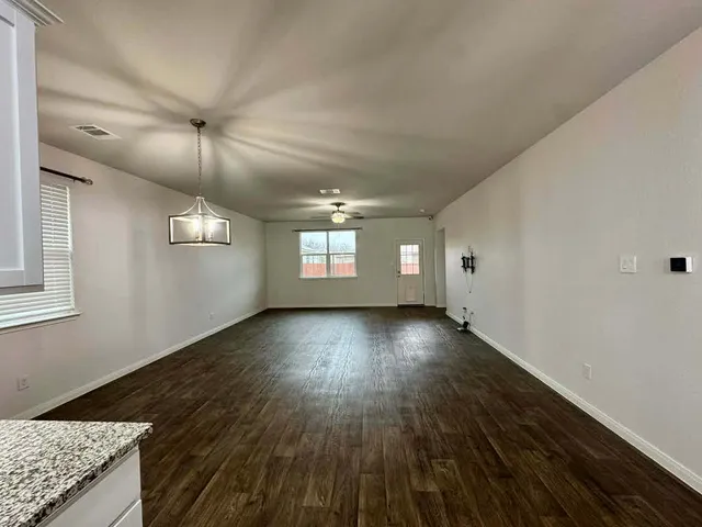 a spacious bedroom with a large bed and a chandelier
