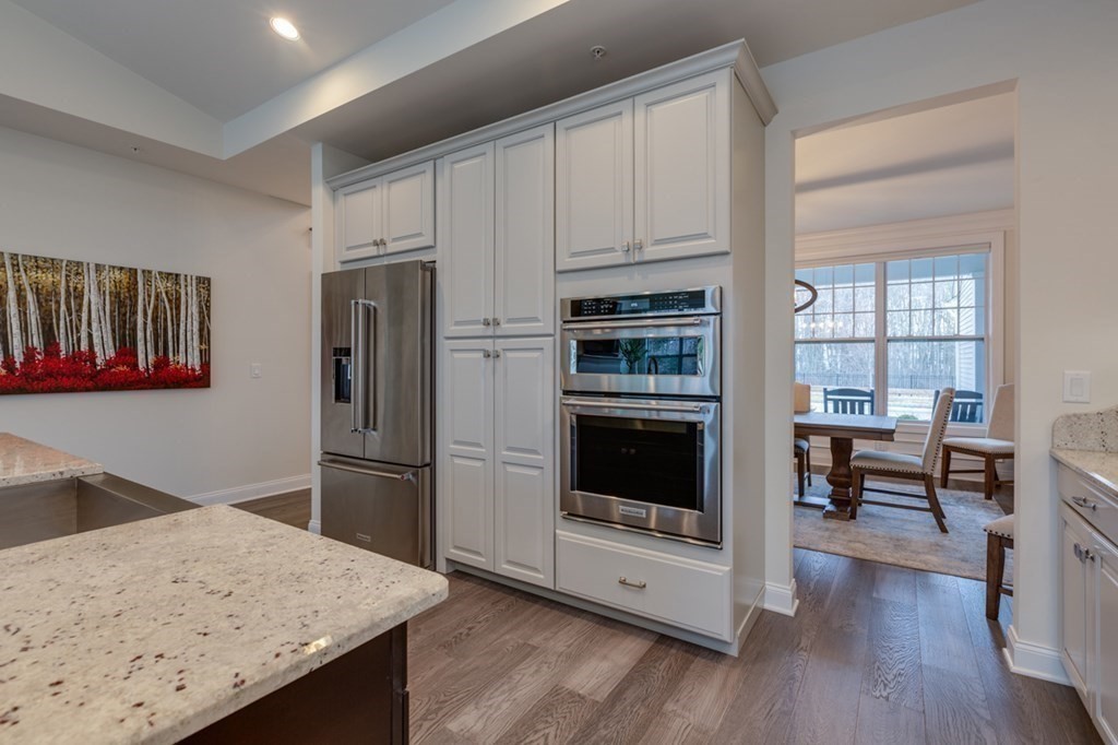 3 Hummingbird Way, Unit 3 Methuen, MA 01844 - Photo 9 of 36 a kitchen with stainless steel appliances kitchen island granite countertop a refrigerator stove and sink