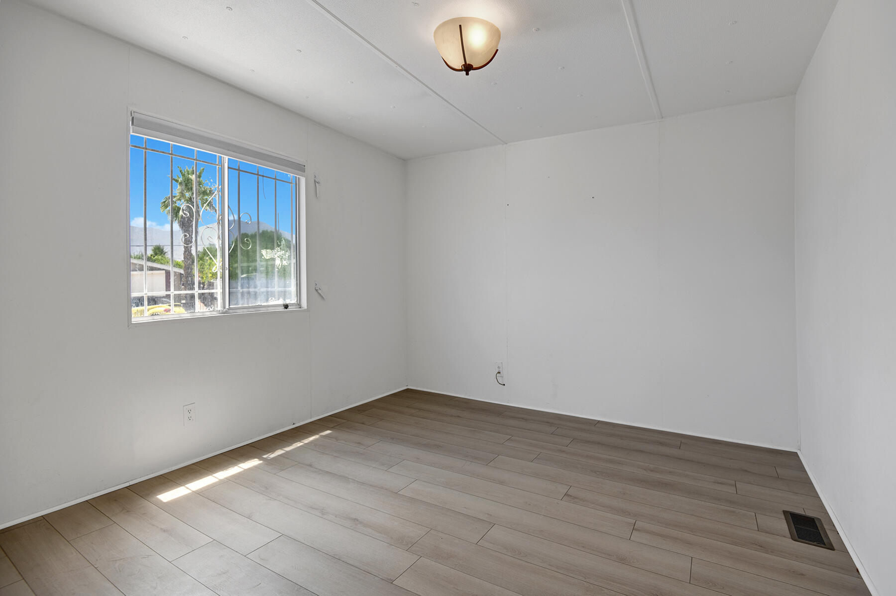 32121 Oakland Hills Street Thousand Palms, CA 92276 - Photo 14 of 20 wooden floor in an empty room with a window