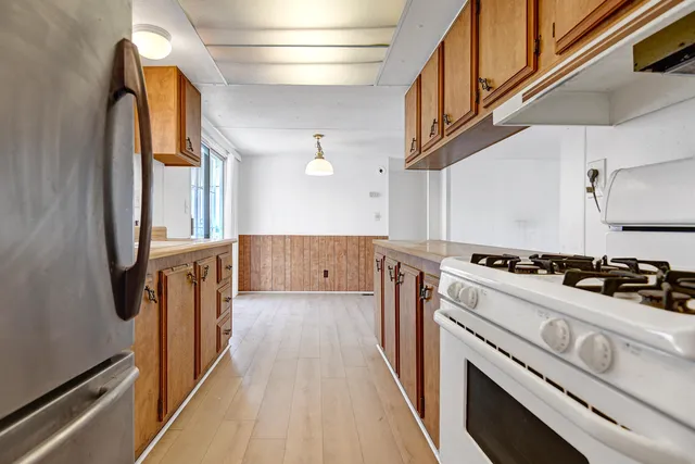 a kitchen with stainless steel appliances granite countertop a stove a sink and a refrigerator