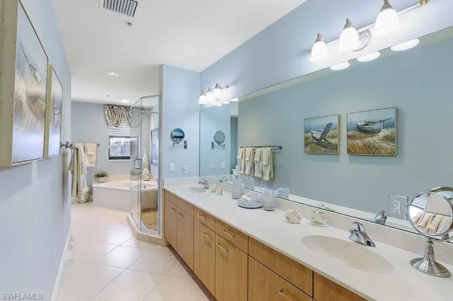 a spacious en suite bathroom with a double vanity sink and a mirror