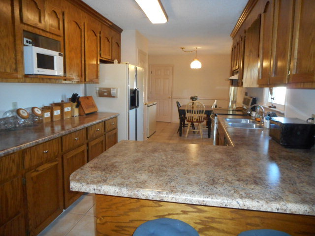 734 Joe Barnes Road Byron, GA 31008 - Photo 14 of 24 a kitchen with stainless steel appliances granite countertop sink stove refrigerator and cabinets