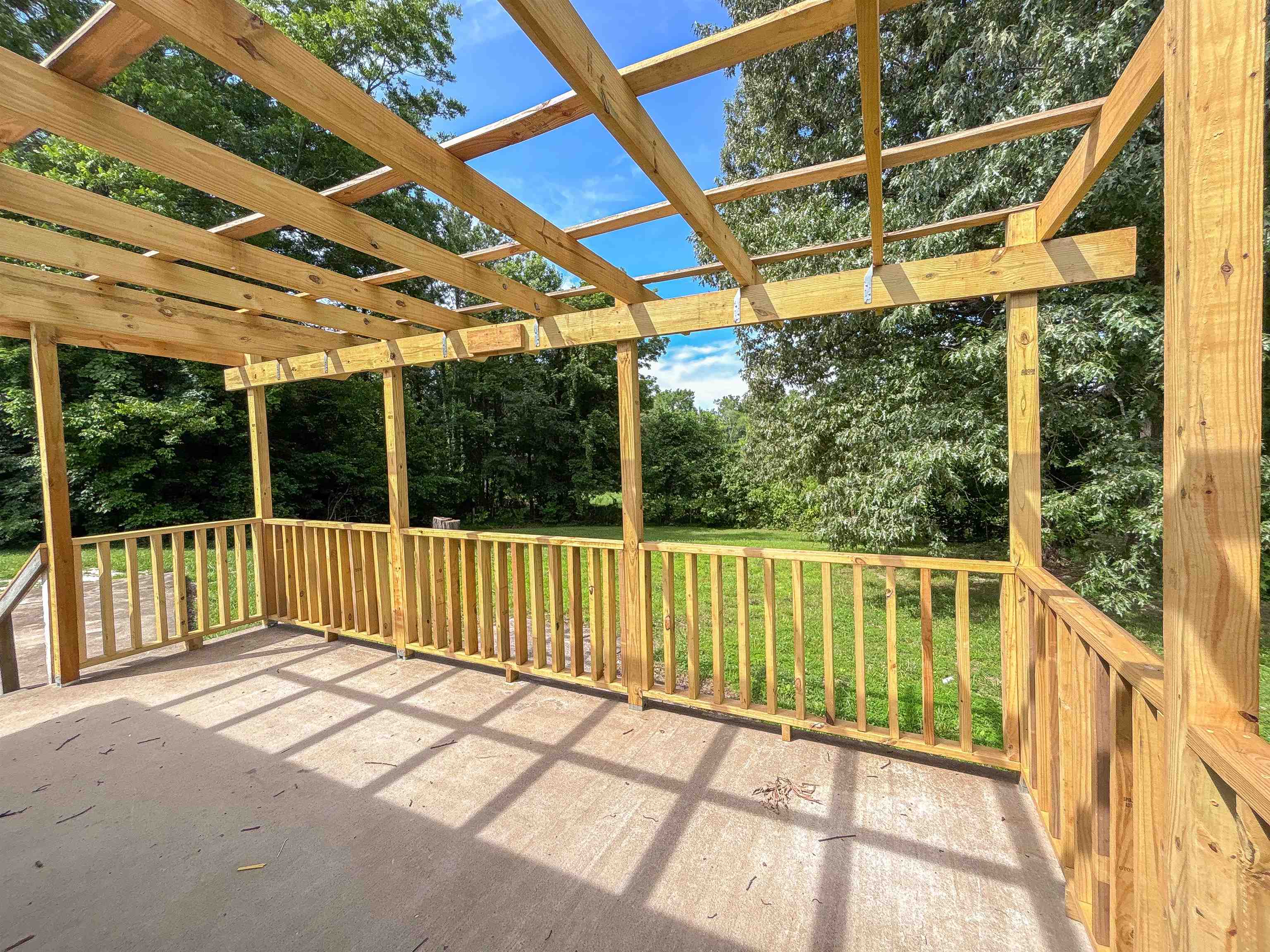 2847 Holly Grove Road Covington, TN 38019 - Photo 34 of 36 Expansive outdoor patio featuring a wooden pergola, concrete flooring, and wooden balustrade