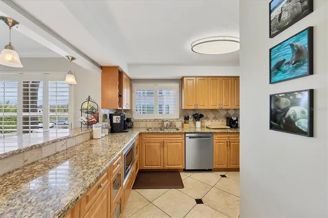 a large kitchen with a stove a sink dishwasher and cabinets