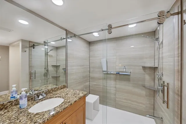a bathroom with a granite countertop sink and a mirror