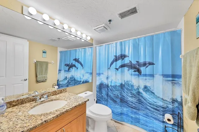 an aerial view of a city with lots of residential buildings ocean and mountain view in back