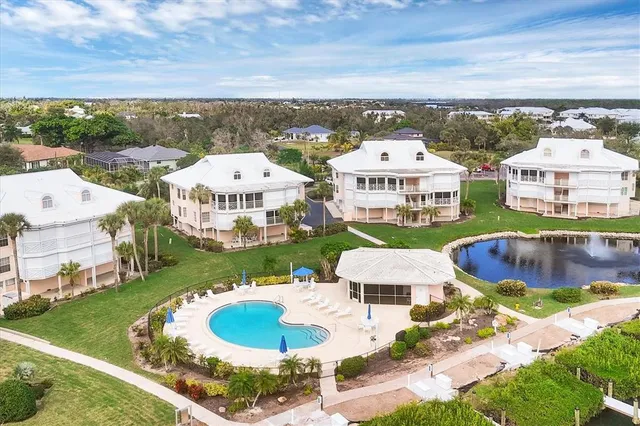 an aerial view of a city with lots of residential buildings ocean and mountain view in back