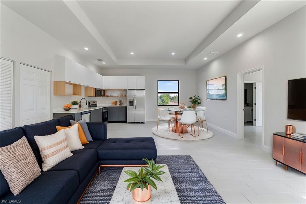 4173 58th Avenue Northeast Naples, FL 34120 - Photo 3 of 15 Living area with a tray ceiling, baseboards, and recessed lighting