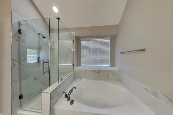 a white bath tub sitting next to a shower