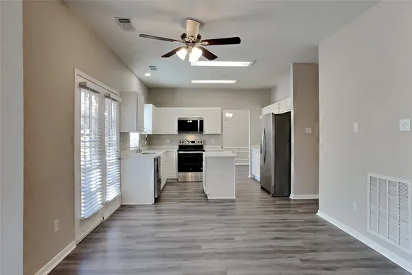 a view of kitchen with stainless steel appliances refrigerator stove microwave and cabinets