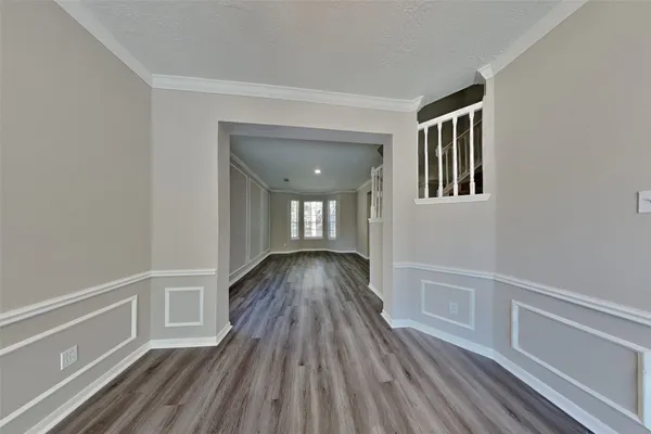 a view of a hallway with wooden floor and a window