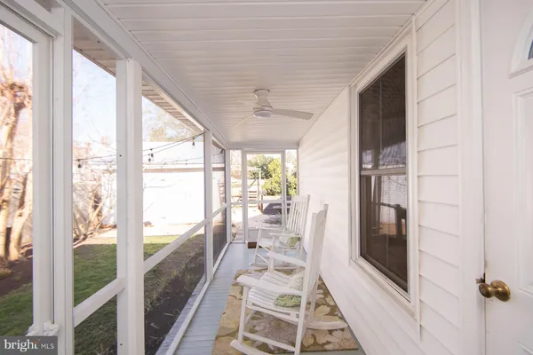 a view of a balcony with chairs and wooden floor