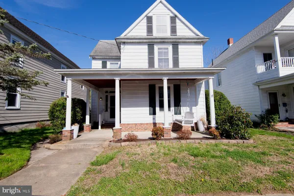 a front view of a house with a yard table and chairs