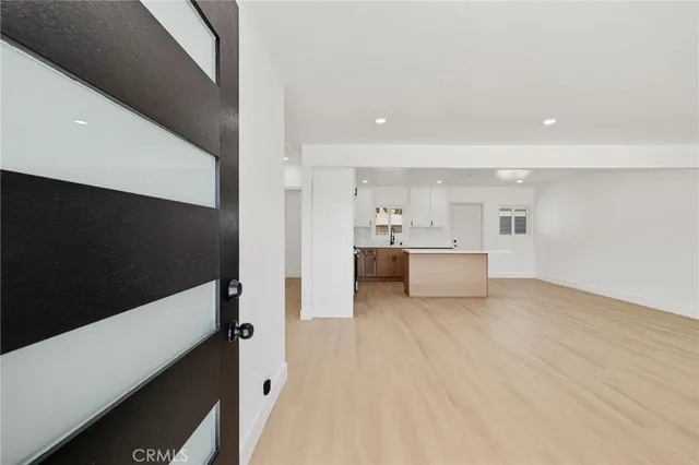 a view of a living room with kitchen furniture and a flat screen tv
