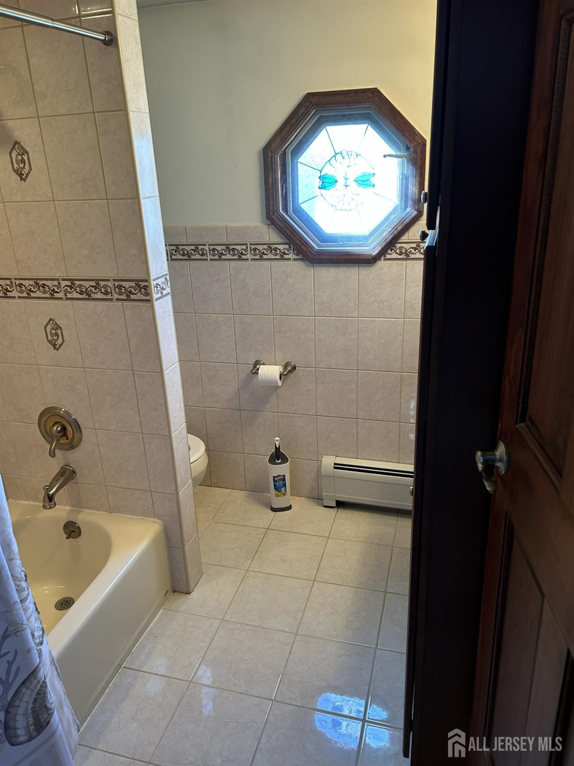 73 Edgar Street Carteret, NJ 07008 - Photo 4 of 5 a bathroom with a tub a sink and a mirror