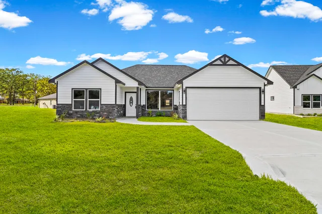a front view of house with yard and green space