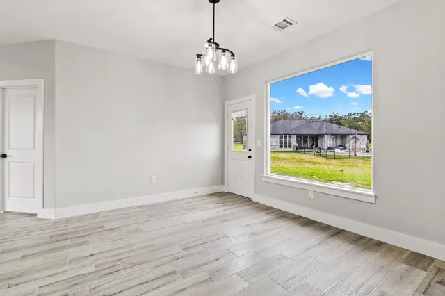 a view of a room with window wooden floor and front door