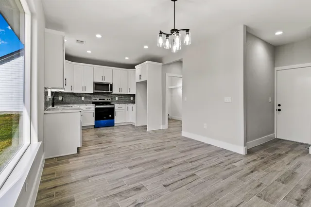 a large kitchen with stainless steel appliances granite countertop a stove and a refrigerator