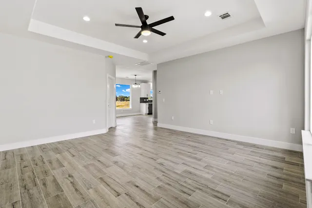 an empty room with a window and a fan