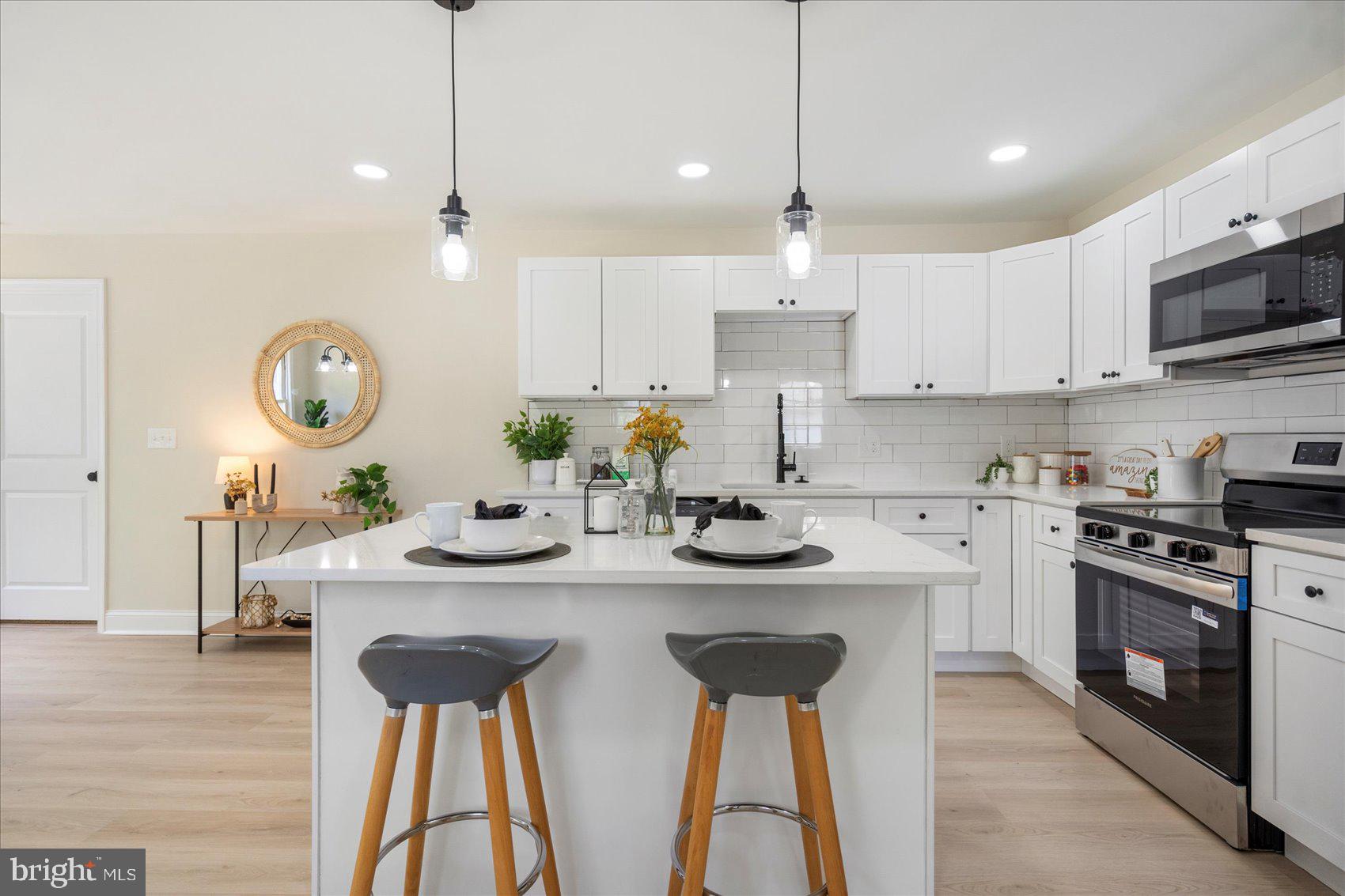 8111 Holly Road Curtis Bay, MD 21226 - Photo 11 of 46 a kitchen with stainless steel appliances granite countertop a sink a stove a dining table and chairs