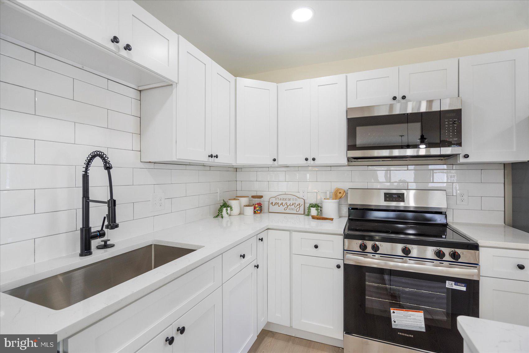 8111 Holly Road Curtis Bay, MD 21226 - Photo 15 of 46 a kitchen with cabinets stainless steel appliances a sink and a stove