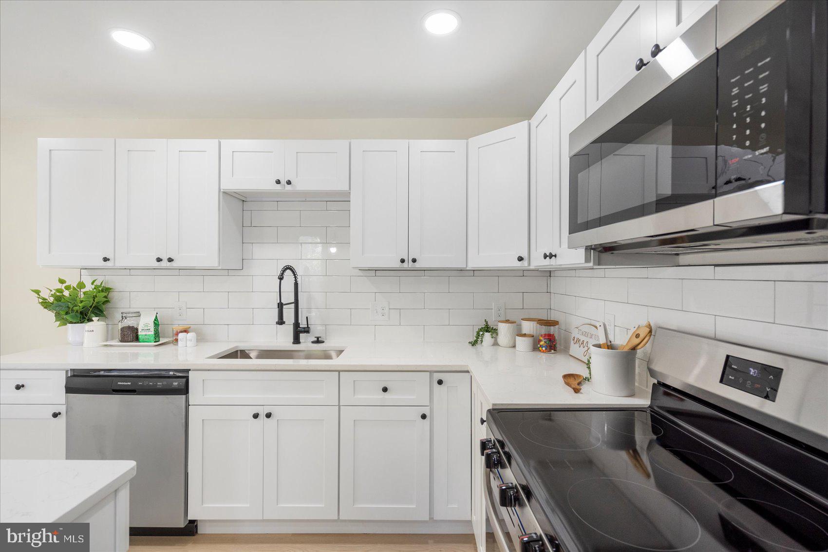 8111 Holly Road Curtis Bay, MD 21226 - Photo 16 of 46 a kitchen with stainless steel appliances a stove a sink and cabinets