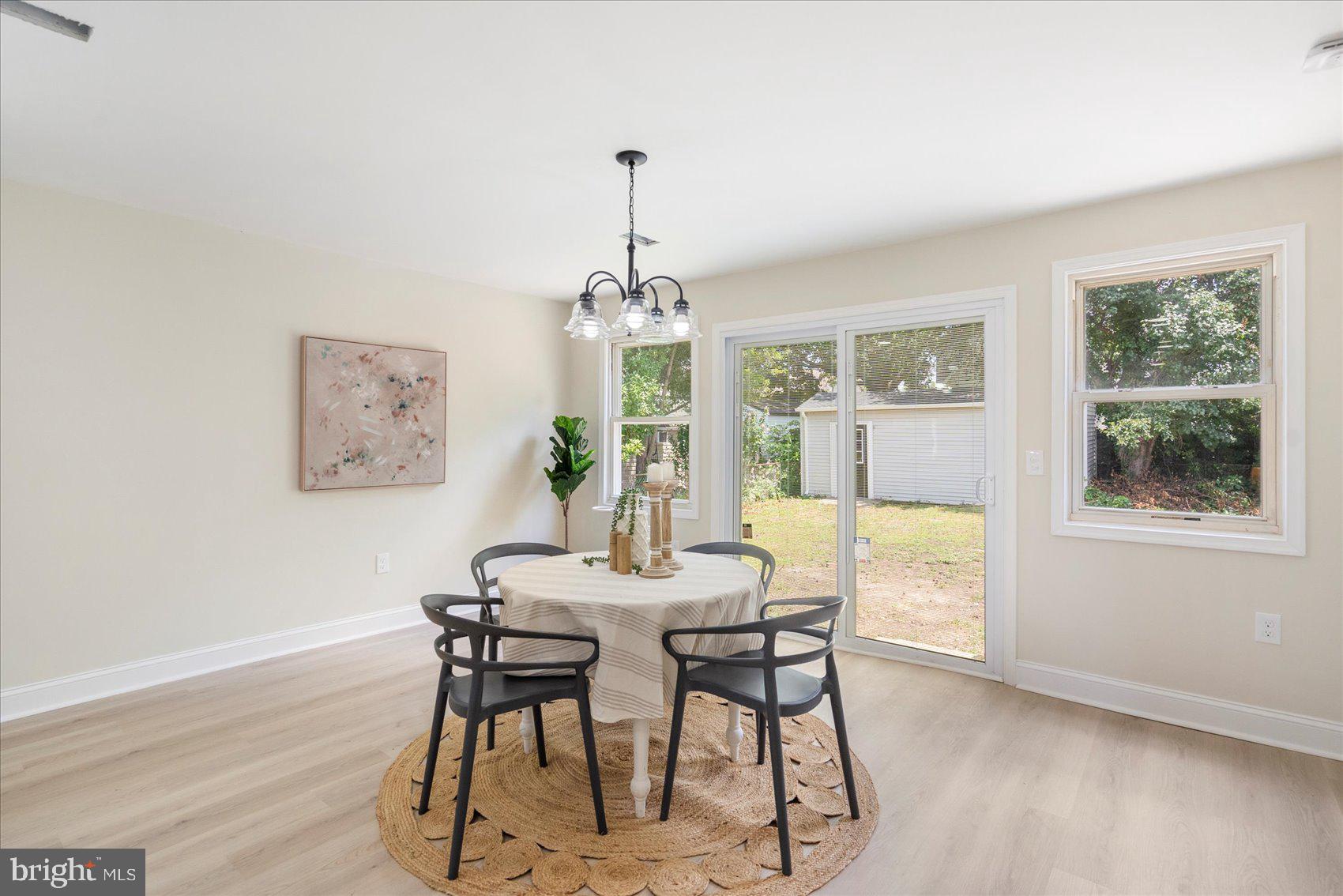 8111 Holly Road Curtis Bay, MD 21226 - Photo 19 of 46 a dining room with furniture a chandelier and wooden floor