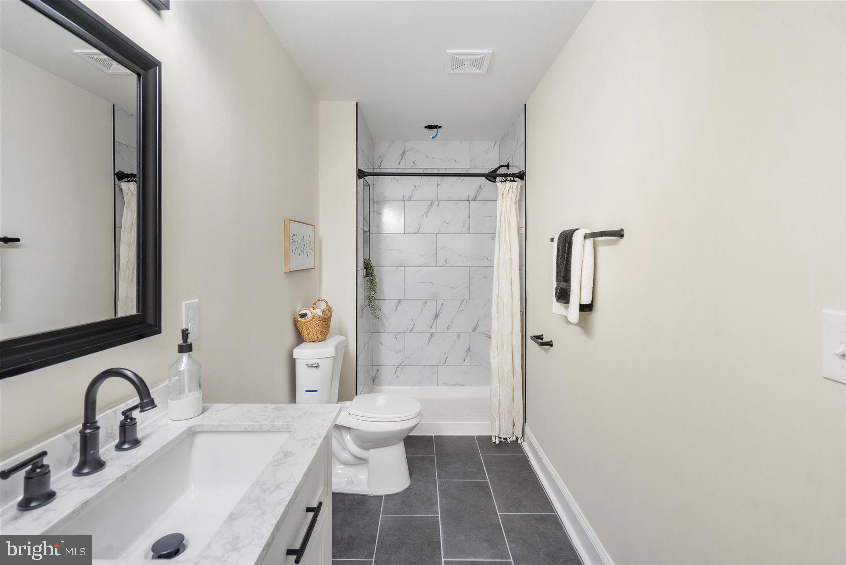 8111 Holly Road Curtis Bay, MD 21226 - Photo 29 of 46 a bathroom with a sink toilet and shower