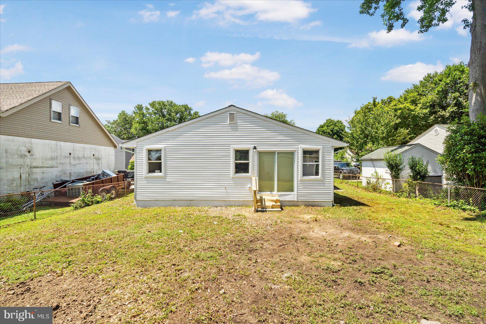 8111 Holly Road Curtis Bay, MD 21226 - Photo 42 of 46 a backyard of a house with table and chairs under an umbrella