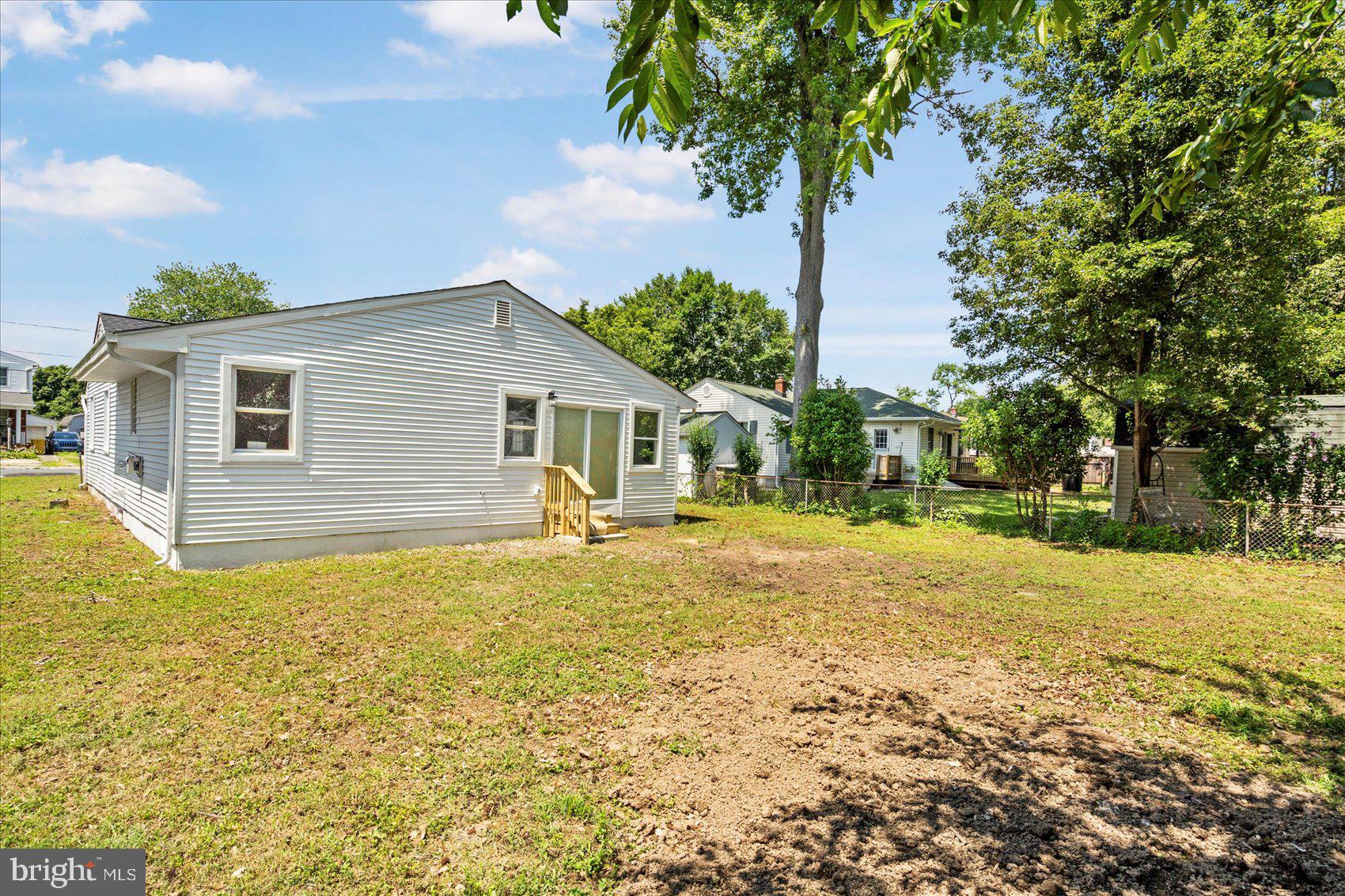 8111 Holly Road Curtis Bay, MD 21226 - Photo 43 of 46 a backyard of a house with table and chairs under an umbrella