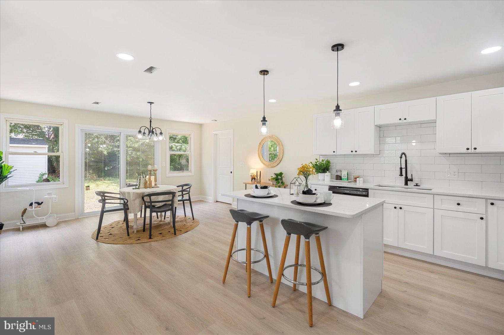 8111 Holly Road Curtis Bay, MD 21226 - Photo 6 of 46 a kitchen with stainless steel appliances granite countertop a table chairs stove and white cabinets