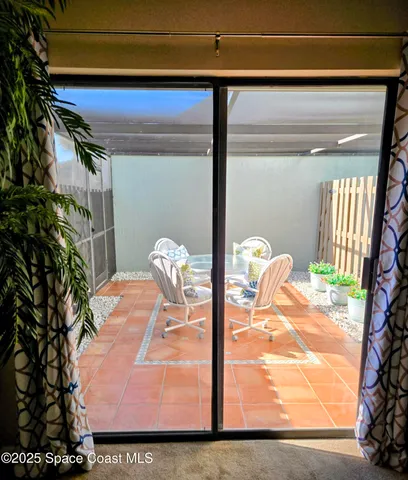 a view of swimming pool with lawn chairs and palm trees