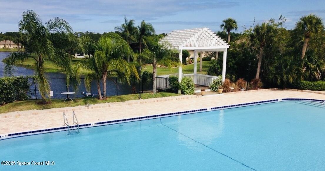 1123 Breezy Way, Unit 8C Sebastian, FL 32958 - Photo 19 of 26 a view of swimming pool with lawn chairs and palm trees