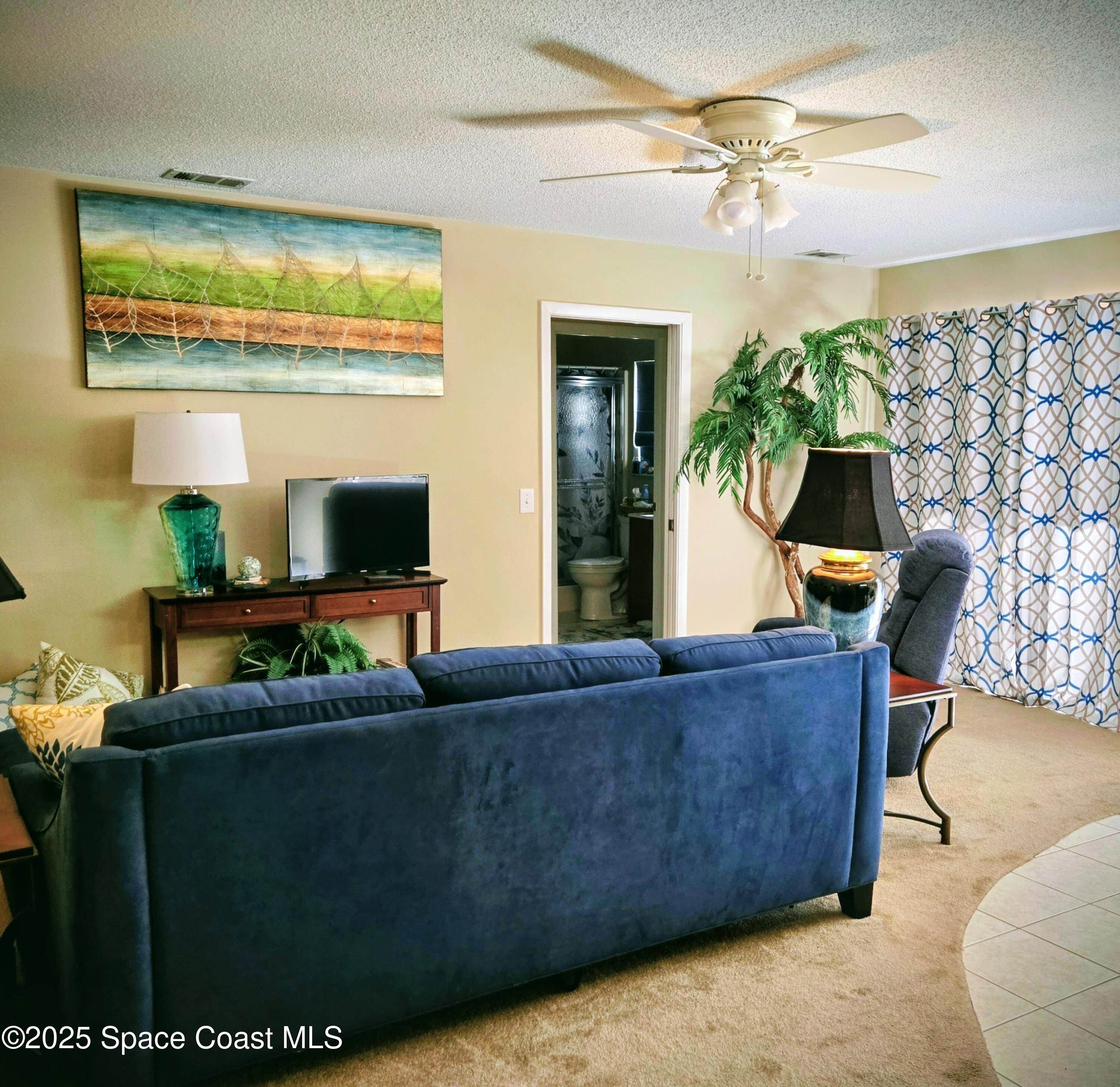 1123 Breezy Way, Unit 8C Sebastian, FL 32958 - Photo 4 of 26 a living room with furniture and a flat screen tv