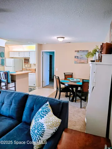 a living room with furniture and a dining table with kitchen view